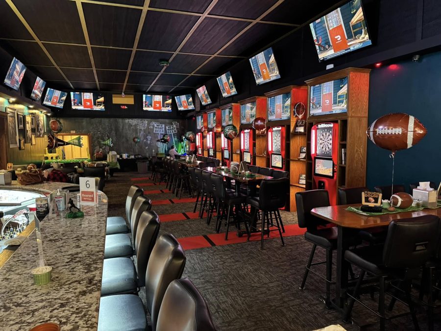 The main room at The Pump 2.0 with the bar, dart machines and TVs